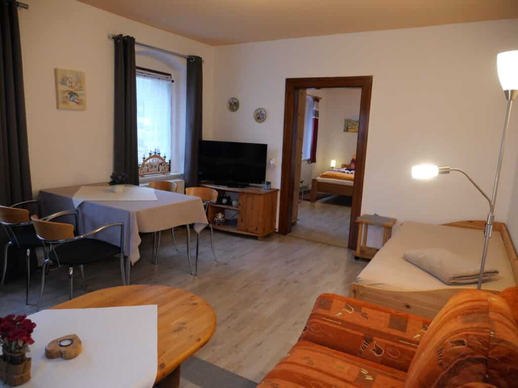 Ferienwohnung 1: Wohnbereich mit Blick ins Schlafzimmer