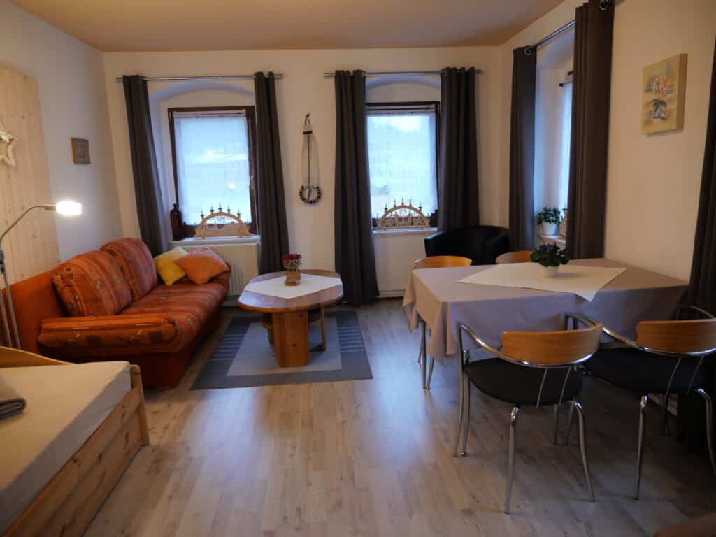 Ferienwohnung 1: Wohnraum mit Sofa und Essplatz